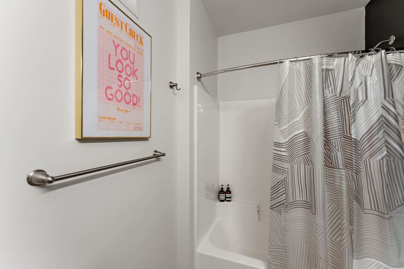 Une salle de bain avec un rideau de douche, une barre d'appui et un panneau encadré indiquant « Registre des clients ».