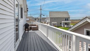 A wooden deck with a white railing, a barbecue grill, and a seating area. - Hampton Beach, Free Parking, Sunsets (Hampton)