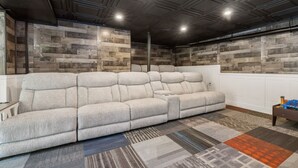 Una sala moderna con un sofá modular, un tapete estampado y una pared de acento de madera.