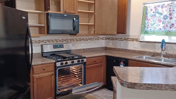 A kitchen with a refrigerator, stove, oven, microwave, and sink. - Charming 1-bedroom house in Riverside (Riverside)