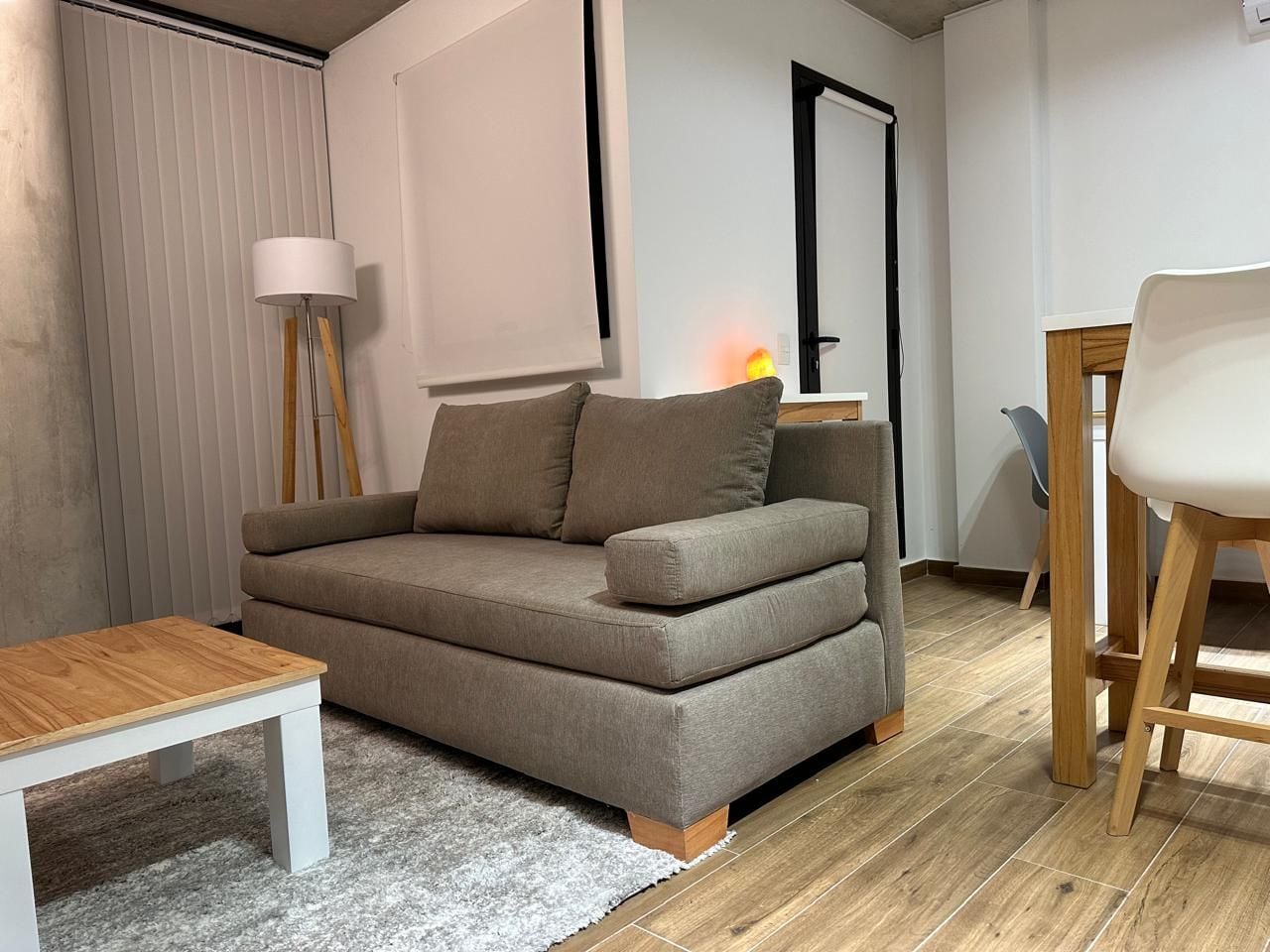 Ein Wohnzimmer mit einer Couch, einem Couchtisch und einem Sessel.