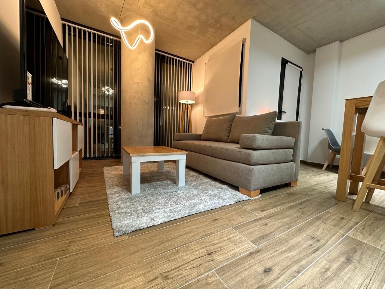 A modern living room with a sofa, a coffee table, and a wooden cabinet.
