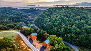 An aerial view of a forested area with a winding road and a few buildings with red roofs. - HUGE Heated Indoor Pool, 2 King Beds, A+ Location, Arcade (Sevierville)