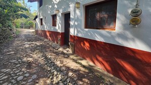 A building with a white and red facade, a stone pathway, and a wooden door. - MEXICAN HOUSE WITH LOVE (San Sebastián del Oeste)