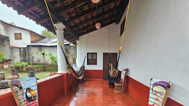 A covered patio with two hammocks, a red-tiled floor, and a white wall with a window. - MEXICAN HOUSE WITH LOVE (San Sebastián del Oeste)
