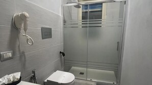 Une salle de bain moderne équipée de toilettes, d’un lavabo et d’une douche.
