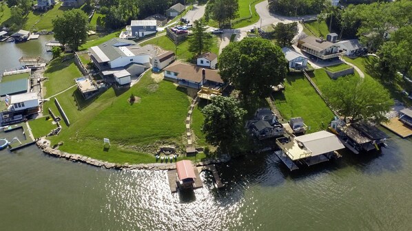 An aerial view of a residential area with houses, a dock, and a small boat.