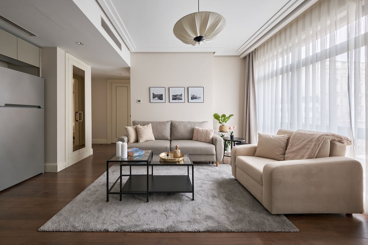Una sala moderna con sofá, mesa de centro y comedor con refrigerador.