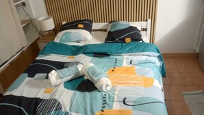 Un lit avec une couvre-lit à motifs, des oreillers et une couverture.