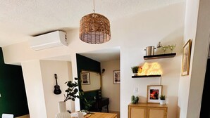 Una cocina moderna con una isla de madera, armarios blancos y una lámpara colgante.
