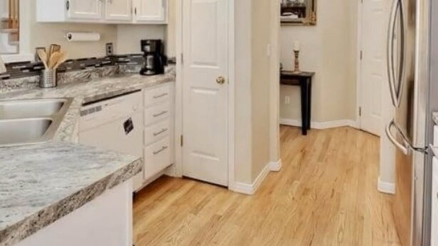 A modern kitchen with white cabinets, a granite countertop, and a stainless steel refrigerator. - Great location for your Aurora visit (Aurora)