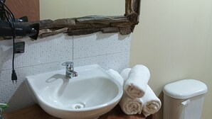 A bathroom with a rustic wooden vanity, a white sink, and a toilet. - El roble cabins (Caburgua)