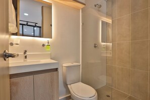 A bathroom with a toilet, sink, mirror, and shower. - Aiana Verde by Host Medellin (Medellín)