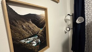 A bathroom with a framed landscape painting, a wall-mounted lamp, and a curtain. - 3 Bedroom - Creek Access Alaskan Blackstone Retreat (Anchorage)