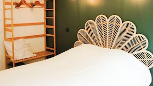 Un dormitorio con una litera, una cama grande y un panel decorativo en la pared.