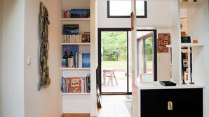 Un interior moderno con piso de madera, una estantería y vistas al exterior.