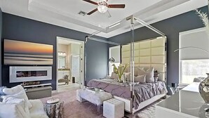 Une chambre moderne avec un lit à baldaquin, une télévision et une grande fenêtre.