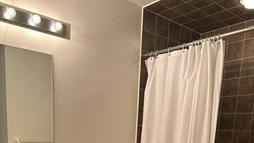 A bathroom with a toilet, sink, and shower curtain.