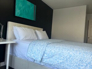 A hotel room with a bed, white headboard, and a nightstand with a lamp. - Private Ensuite Bedroom in Ajax (Ajax)