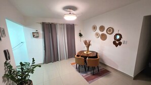 A dining area with a round table, chairs, a potted plant, and decorative wall art. - New! LaRomanaDR SecludedJourney (La Romana)