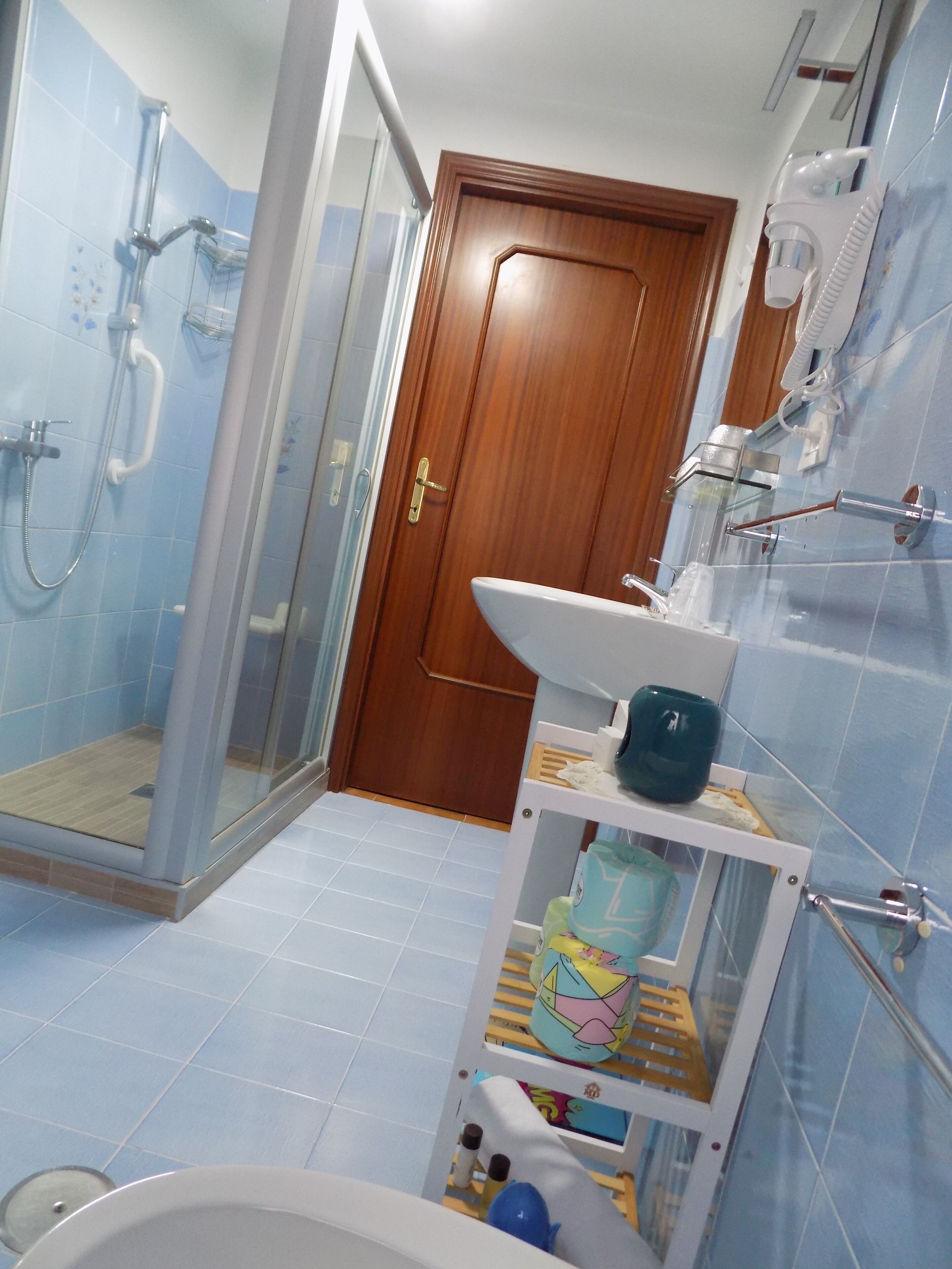 Un baño con ducha, lavamanos e inodoro.