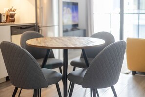 A modern kitchen with a round wooden table surrounded by four grey upholstered chairs. - Sophisticated 1BR Escape | Charm in Old Port (Montreal)