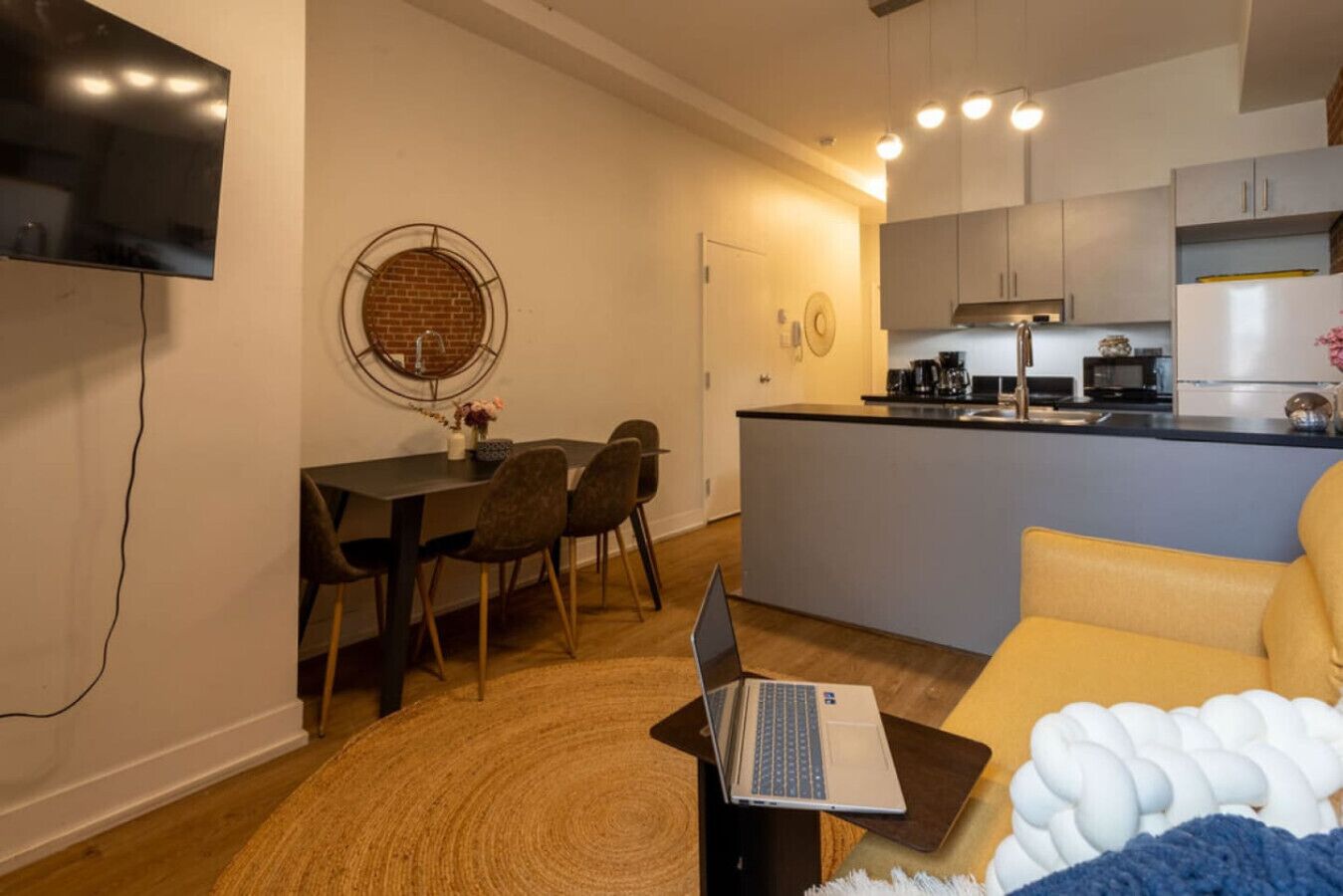A compact living space with a dining area, a kitchen, and a sofa.