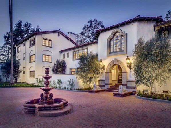 A large, multi-story building with a fountain in the courtyard.