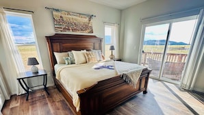 Un dormitorio con una cama grande, vistas al exterior y un cuadro de Florencia en la pared.