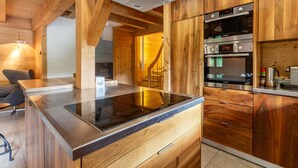 A modern kitchen with wooden cabinetry, a built-in stove, and stainless steel appliances.