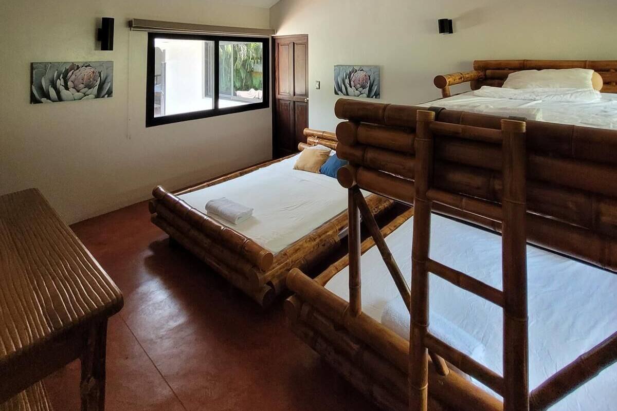 Ein Zimmer mit Etagenbett, Schreibtisch und Fenster.