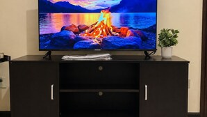 A television on a dark wooden entertainment center with a mountain and lake scene on the screen.