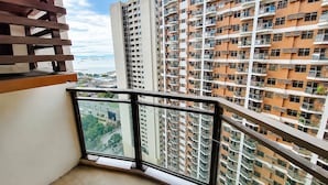 Un edificio residencial alto con varios balcones, ventanas grandes y vista al mar.