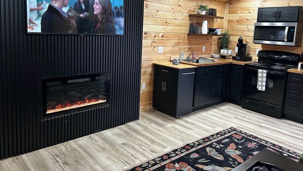 Eine moderne Küche mit integriertem Fernseher, Kamin und Holzvertäfelung.
