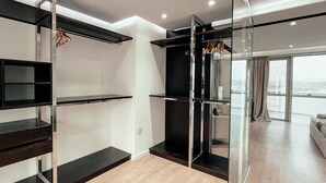 A modern interior with a minimalist design, featuring a glass partition, a wooden staircase, and a view of the city through large windows. - DELUXE MIRAFLORES DUPLEX (Tangier)