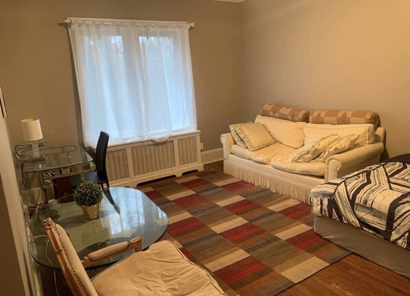 A living room with a glass dining table, a sofa, and a patterned rug. - Room in the safest neighbourhood in Toronto (Toronto)
