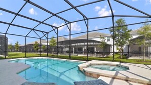 A pool area with a glass enclosure, lounge chairs, and a hot tub. - Enchanted Dreams (Kissimmee)