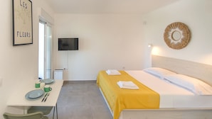 A hotel room with a bed, a desk with a chair, a television, and a framed picture on the wall. - WELCS ESTUDIO 269 EMP con vista al mar (Rosas / Roses)