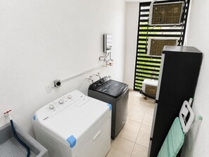 A laundry room with a washing machine, a dryer, and a water heater.