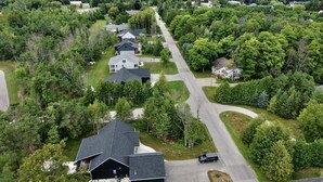 Vista aérea de una zona residencial con casas, calles y vegetación circundante.