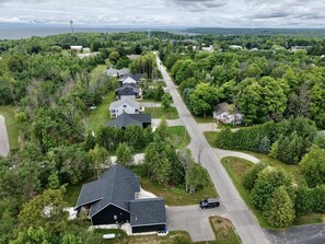 An aerial view of a residential area with houses, roads, and surrounding greenery.