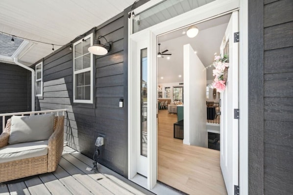 A modern house with a covered porch, a dining area, and a living room.