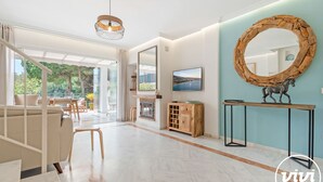 A modern living room with a large mirror, a television, and a fireplace. - Lochloosa | Pool - terrace - golf (Marbella)