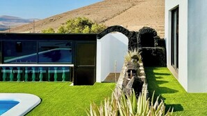 A modern house with a swimming pool, a covered outdoor area, and a view of a mountain. - Canaryislandshost l Olympica 7 (Tahiche)