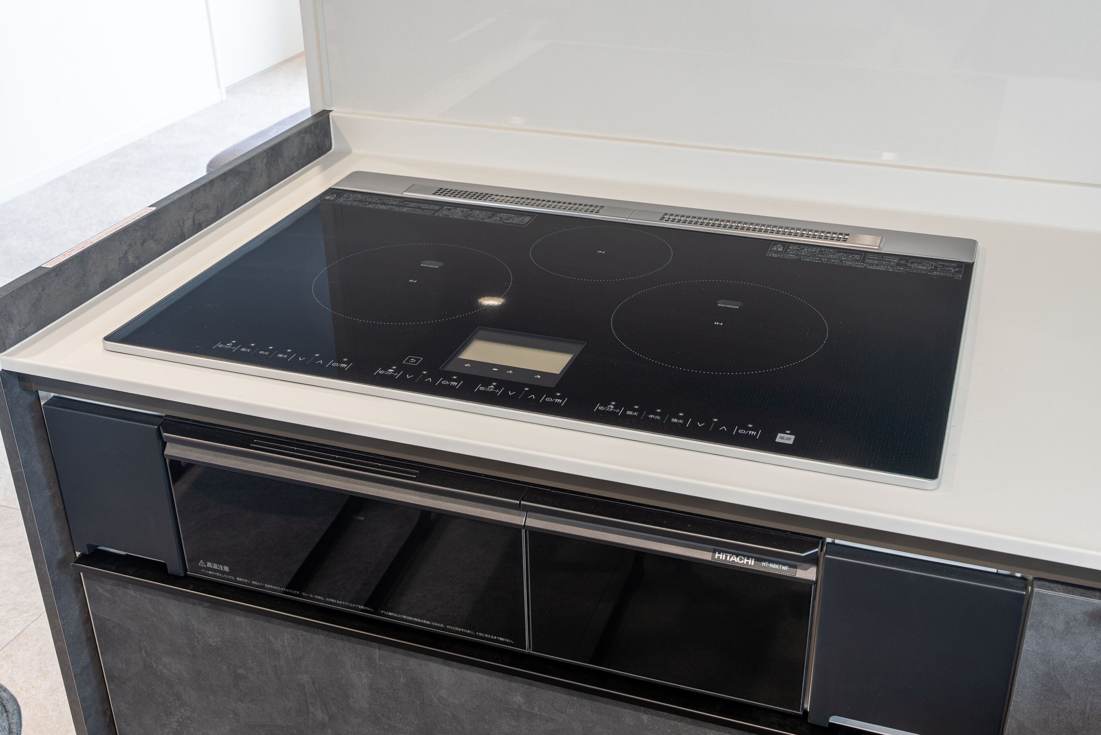 A kitchen with a built-in induction cooktop, a dishwasher, and a microwave.