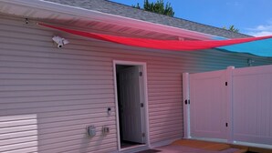 Un bâtiment doté d’un garage fermé, d’une petite porte et d’un patio abrité.