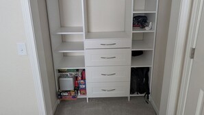 Un dressing avec des étagères ouvertes, des tiroirs et une tringle pour suspendre les vêtements.
