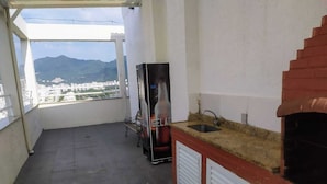 Un petit balcon donnant sur un paysage urbain et des montagnes.