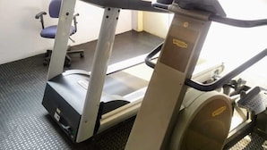 Un tapis de course dans une pièce avec une fenêtre, une chaise et une porte.