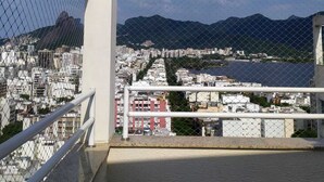 Un balcon offrant une vue sur la ville et les montagnes.